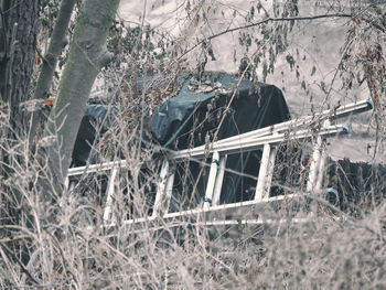 Abandoned vehicle on field in forest