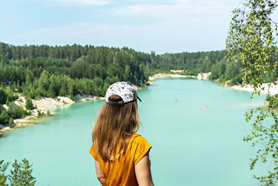 Rear view of woman in lake against sky