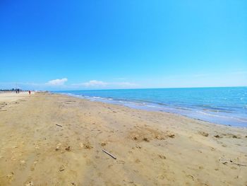 Scenic view of beach against blue sky