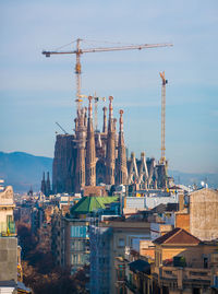 Construction site by buildings against sky