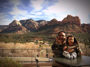 Portrait of smiling mother and son against mountain