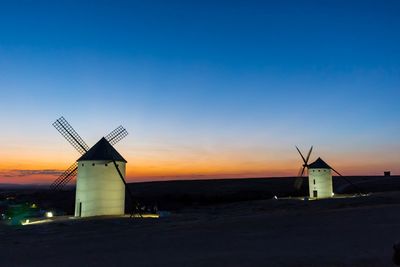 Traditional windmill against sky during sunset