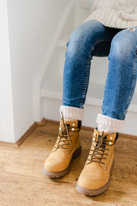 Low section of woman relaxing on hardwood floor at home