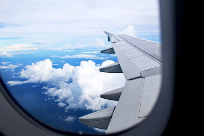 Aerial view of airplane wing over clouds