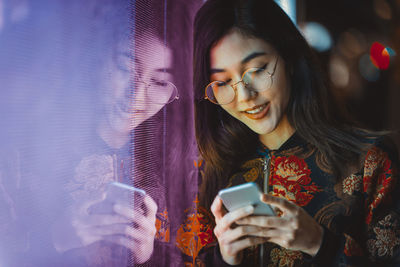 Young woman using mobile phone at camera