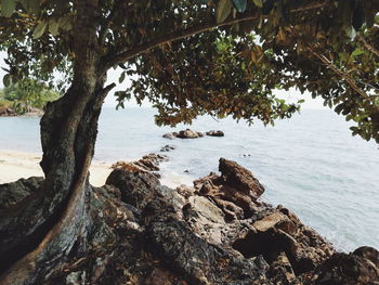 Scenic view of rocks by sea against sky