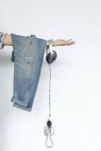 Cropped hand of person holding lamp against white background