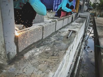 People working on wet sidewalk in city