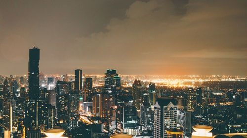 Illuminated cityscape against sky at night