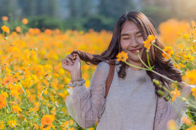 Woman standing on yellow flowering plants