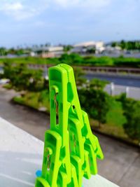 Close-up of green toy on footpath against sky