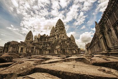 Low angle view of old ruins against cloudy sky