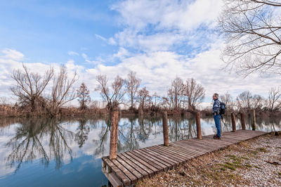 Man standing by lake against sky