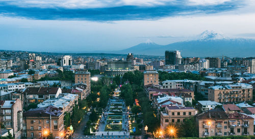 High angle view of illuminated buildings against sky at dusk