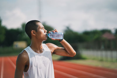 Young woman drinking water from bottle