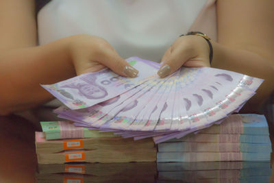 Midsection of woman holding paper currencies