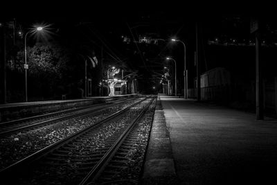 Illuminated railroad tracks at night