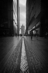 People walking on street amidst buildings in city