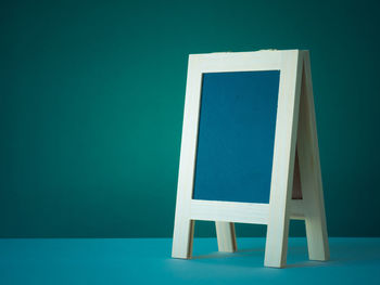 Blue chair on table against wall