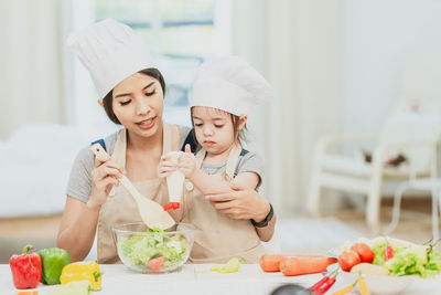 Midsection of woman having food at home