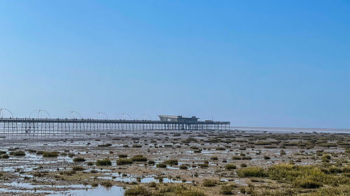 Bridge over sea against clear sky