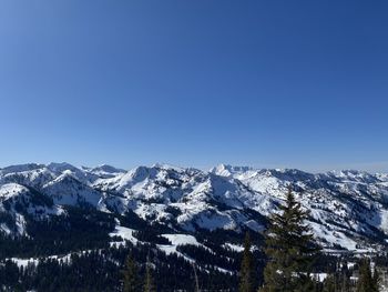 Scenic view of snowcapped mountains against clear blue sky