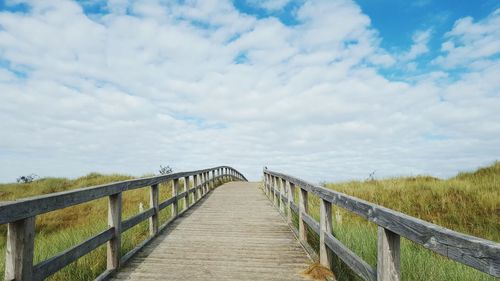 Pier on footbridge against sky