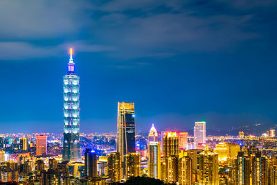 Illuminated buildings against sky at night