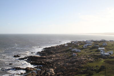 Scenic view of sea and houses against clear sky