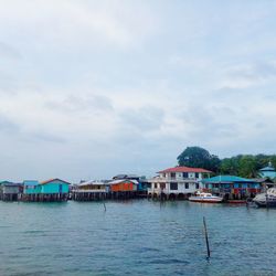 Houses by sea against sky