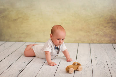 Cute baby girl with toy on floor