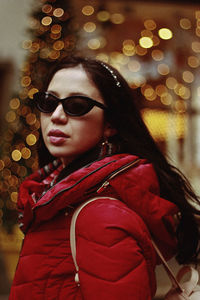  woman in sunglasses with defocused lights in background