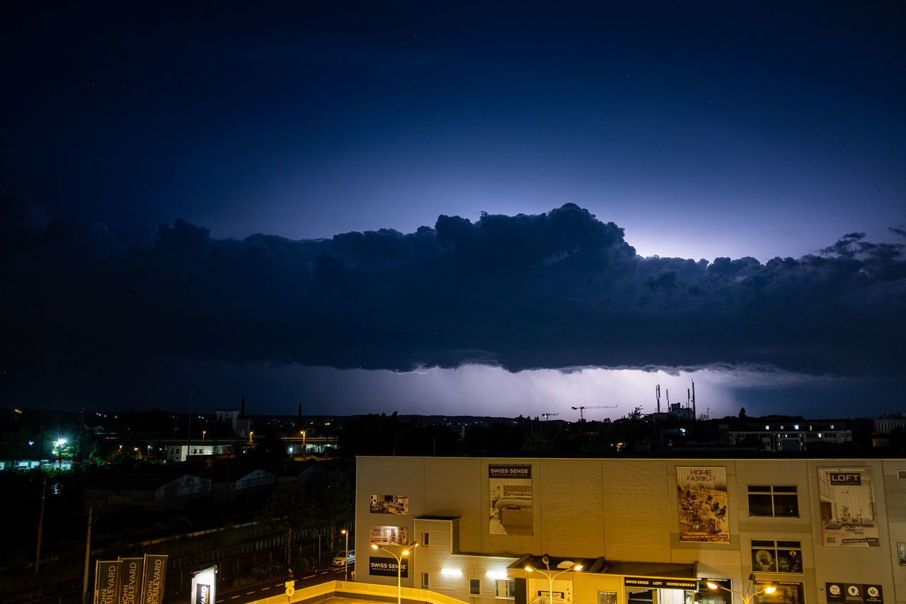 ILLUMINATED CITY AGAINST SKY AT NIGHT