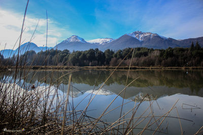 Scenic view of lake by mountains against sky