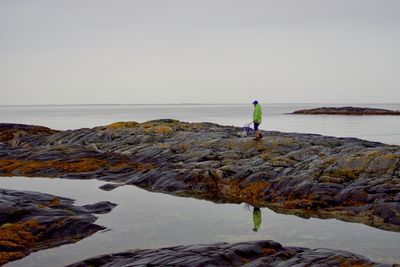 A man and his dog head out to catch some critters in the tide pools 