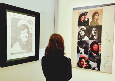 Rear view of woman photographing at museum