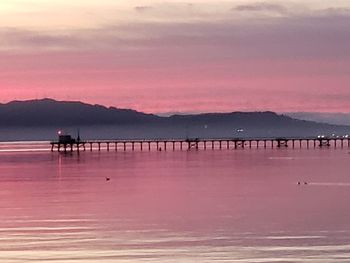 Pier over sea against sky during sunset