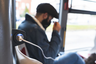 Portrait of man using mobile phone in bus