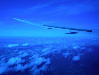 Aerial view of airplane wing against blue sky