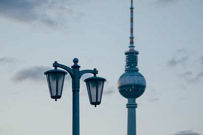 Low angle view of street light against television tower