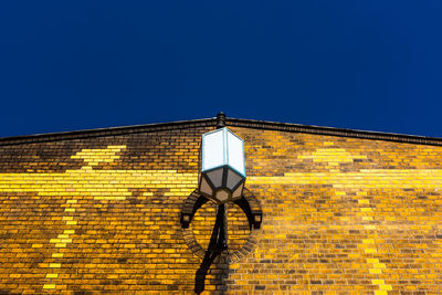 Low angle view of yellow light against building