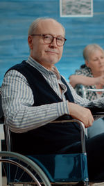 Portrait of senior man sitting on wheelchair at hospital