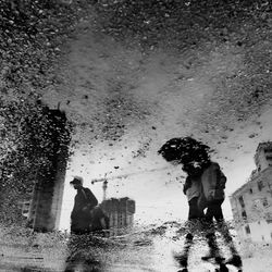 Reflection of people in puddle