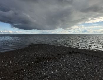 Scenic view of sea against storm clouds
