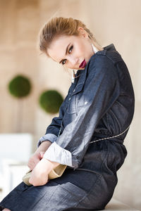 Close-up portrait of beautiful woman standing against wall