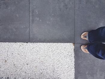 Low section of woman standing on sidewalk