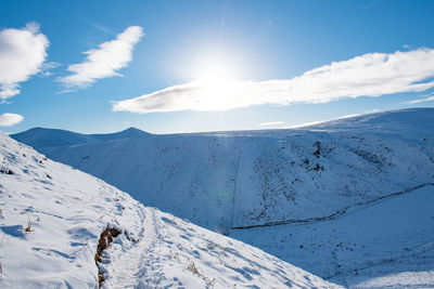 Scenic view of snow covered mountains against sky