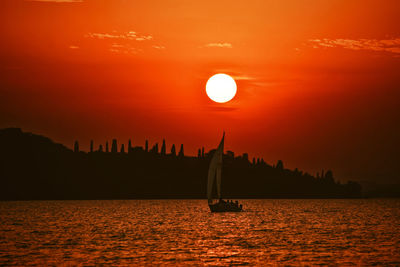 Silhouette of boat in sea at sunset