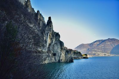 Rock formations by sea against sky