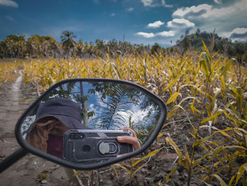 Close-up of camera on field against sky